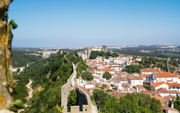 Óbidos town view with medieval walls and castle in Portugal.