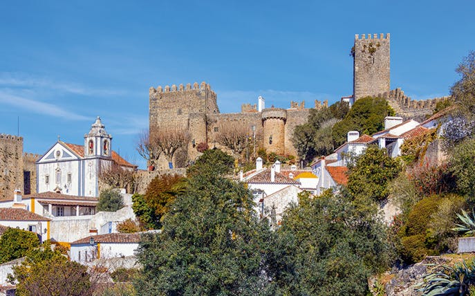 Óbidos castle and village view with historic walls and church, Portugal.