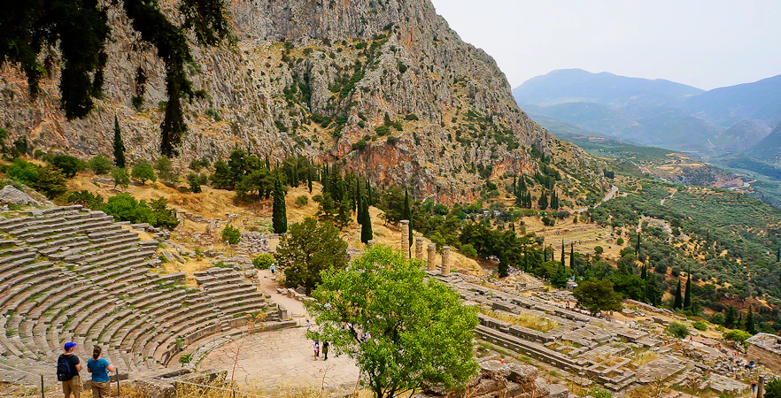 Visitors at the Ancient Theater of Delphi with mountainous landscape in Greece.