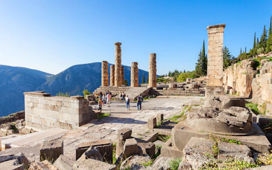 Guests exploring the ancient ruins of the Temple of Apollo in Delphi, Greece.