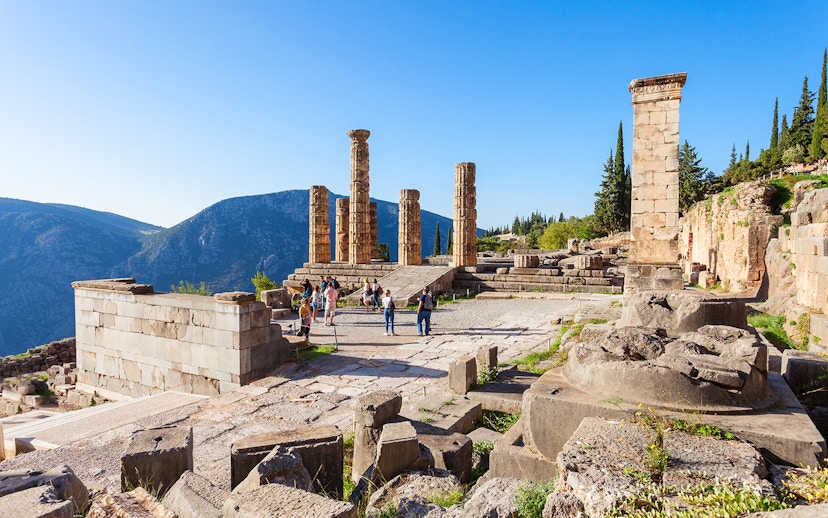 Guests exploring the ancient ruins of the Temple of Apollo in Delphi, Greece.