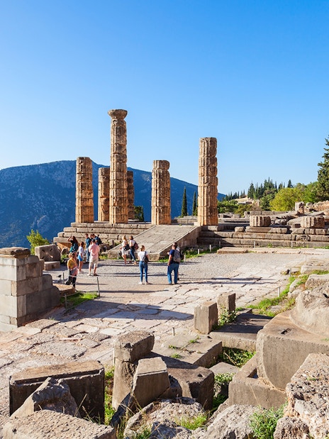 Guests exploring the ancient ruins of the Temple of Apollo in Delphi, Greece.