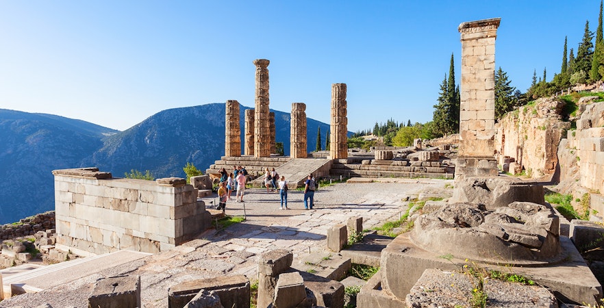 Guests exploring the ancient ruins of the Temple of Apollo in Delphi, Greece.