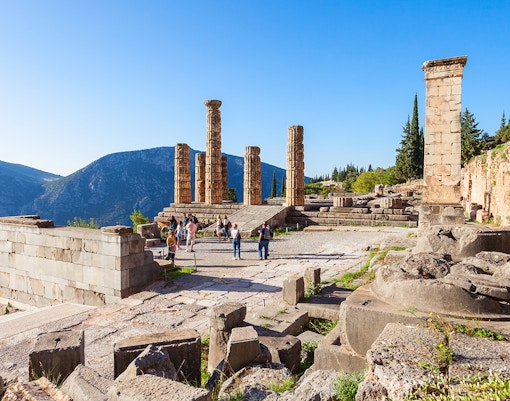 Guests exploring the ancient ruins of the Temple of Apollo in Delphi, Greece.