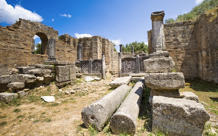 Ancient ruins with columns at Olympia Archaeological Site, Greece.