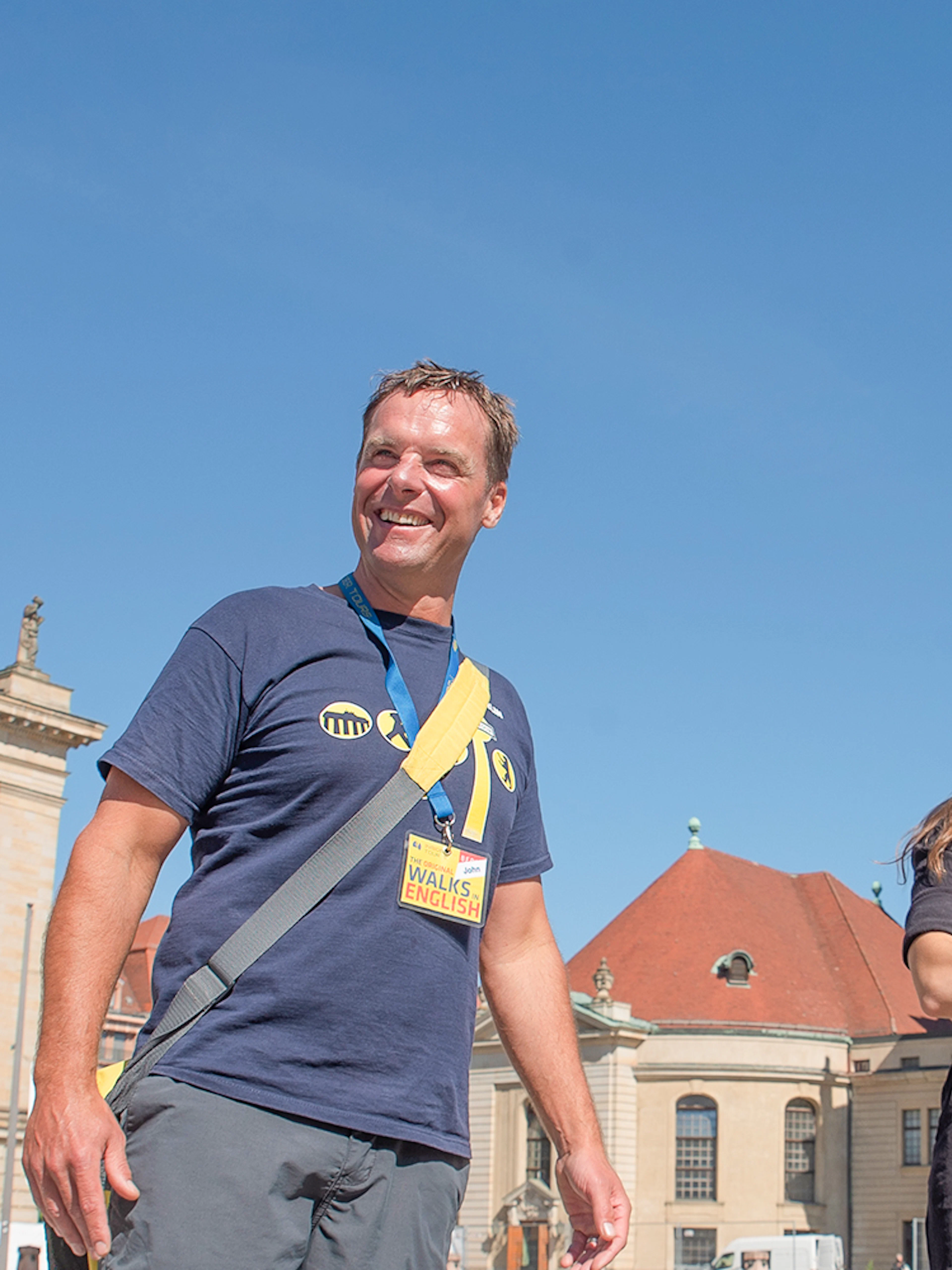 Tour group in front of Berlin's French Cathedral on a sunny day.