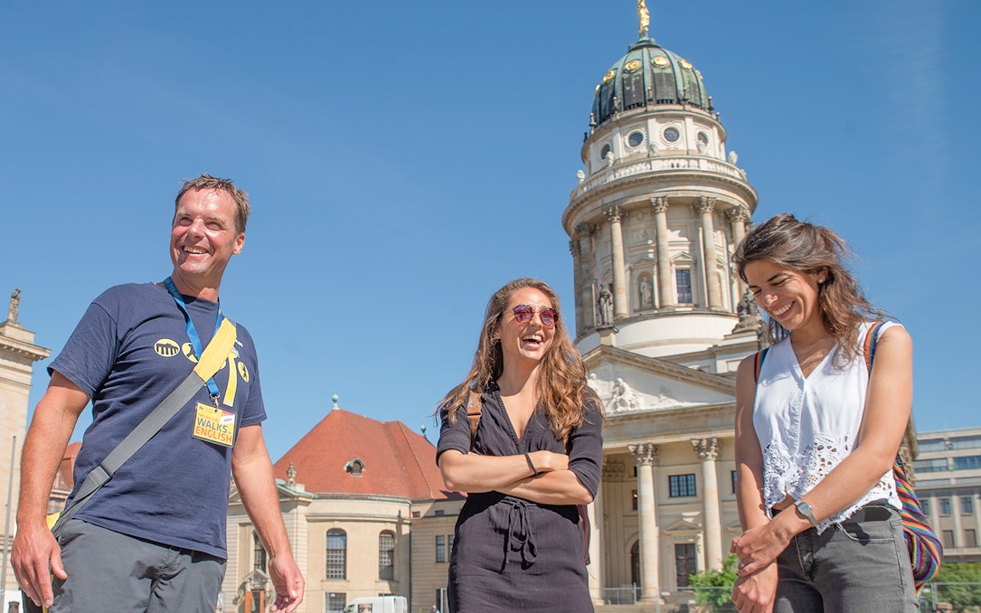 Tour group in front of Berlin's French Cathedral on a sunny day.