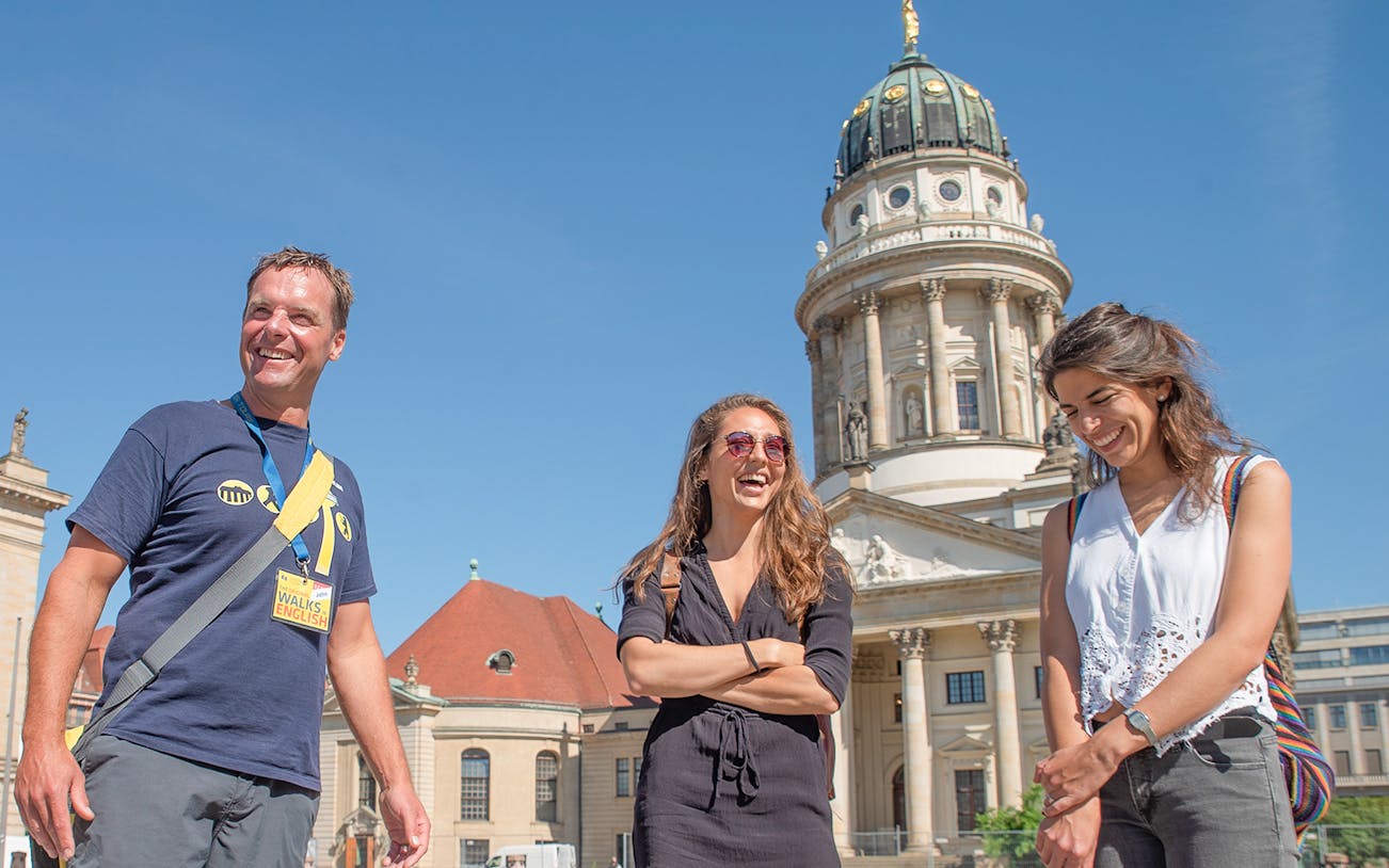 Tour group in front of Berlin's French Cathedral on a sunny day.