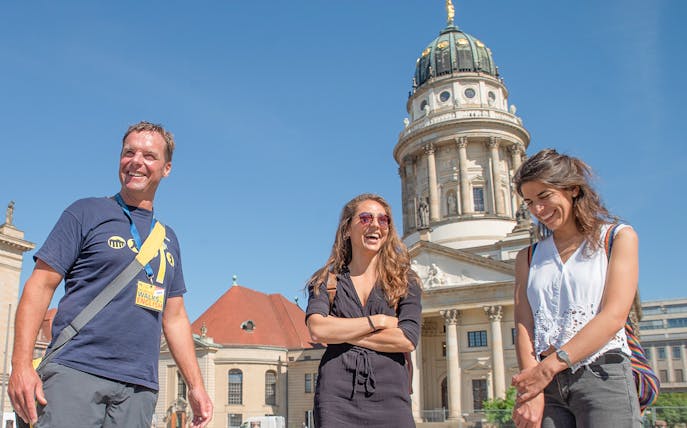 Tour group in front of Berlin's French Cathedral on a sunny day.