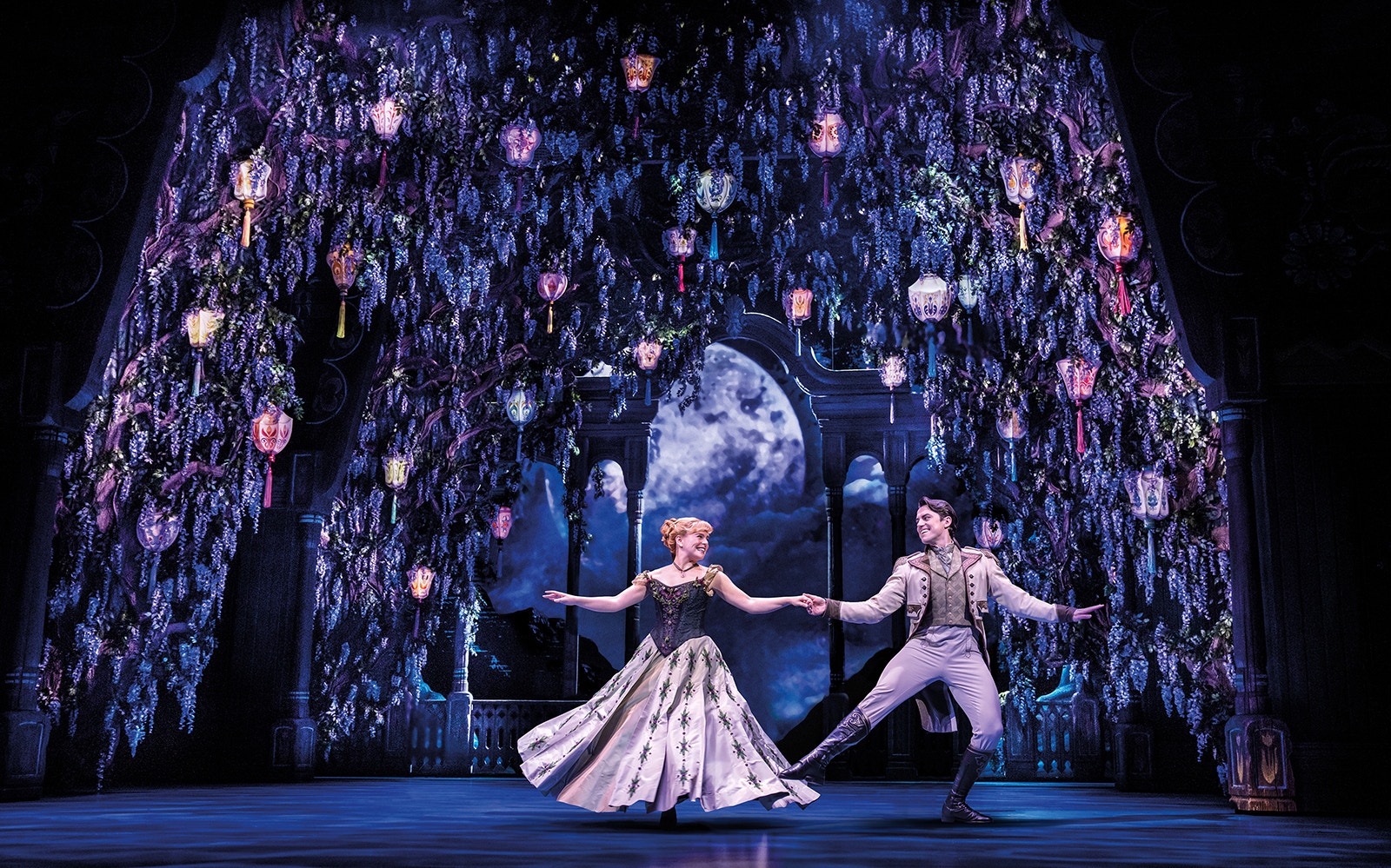 Characters dancing under lanterns in a scene from Frozen The Musical.