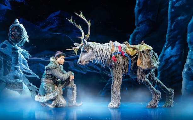 Performer with reindeer puppet on stage in Frozen The Musical.