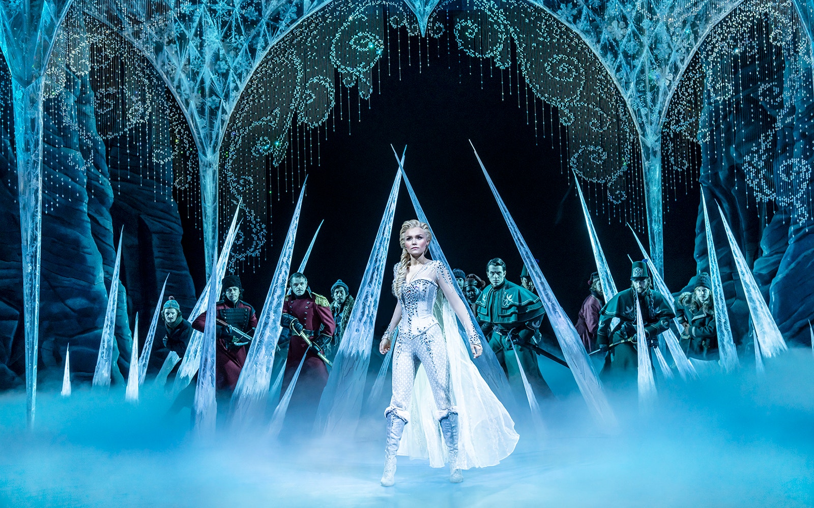 Elsa on stage surrounded by ice in Frozen The Musical.