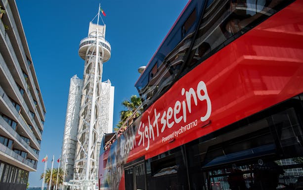 Lisbon sightseeing bus near Vasco da Gama Tower on hop-on hop-off tour.