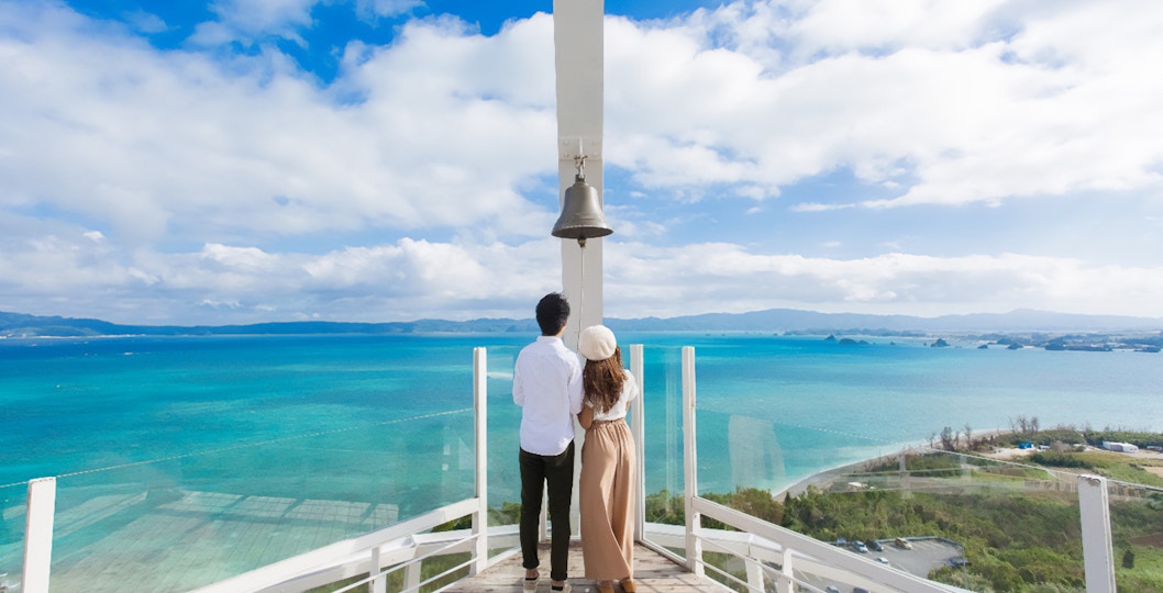 Visitors enjoying the view from Kouri Ocean Tower, overlooking the ocean in Okinawa, Japan.