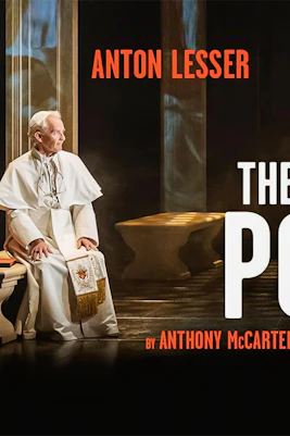 Two men in religious attire seated opposite each other in a dimly lit room, text reads "The Two Popes.