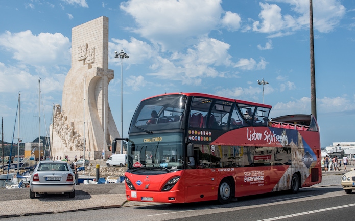 Lisbon sightseeing bus near Padrão dos Descobrimentos monument.