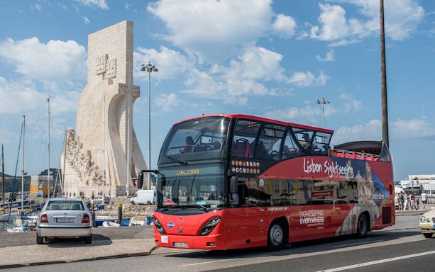 Lisbon sightseeing bus near Padrão dos Descobrimentos monument.