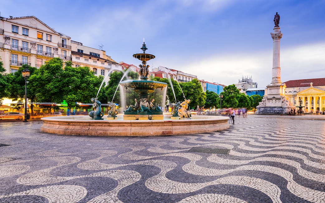 Lisbon's Rossio Square with fountain and column, part of Bus & Boat Hop-On-Hop-Off Tour.
