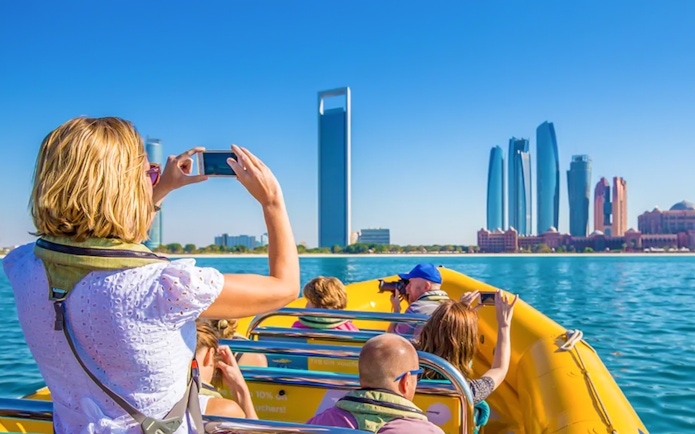 Sightseeing from a yellow speedboat in Abu Dhabi with skyline view.