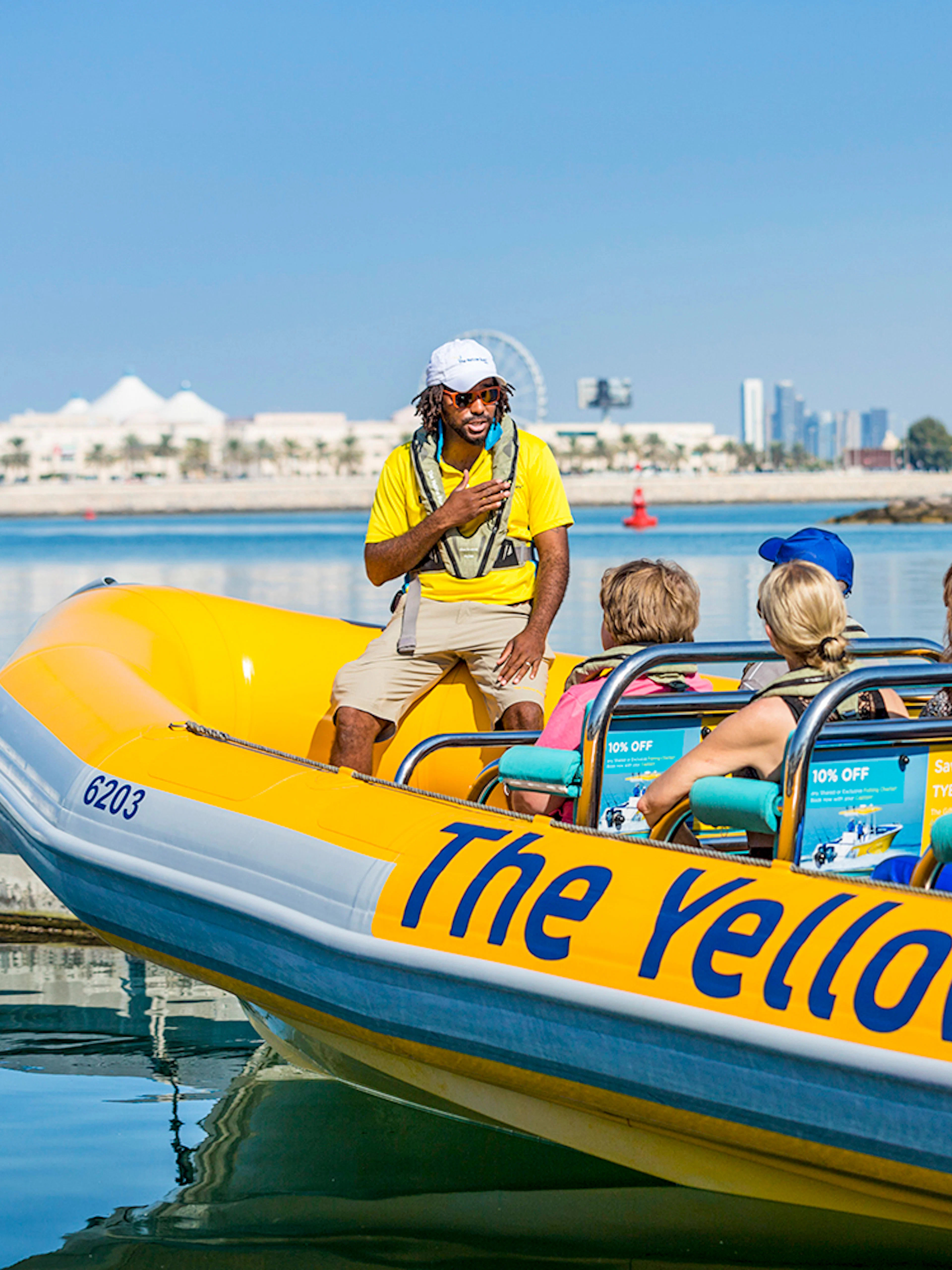 Sightseeing tour on a Yellow Boat in Abu Dhabi with city skyline in background.