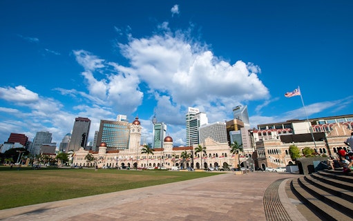 Sultan Abdul Samad Building with Kuala Lumpur skyline on a historical Malacca sightseeing tour.