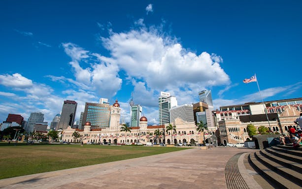 Sultan Abdul Samad Building with Kuala Lumpur skyline on a historical Malacca sightseeing tour.