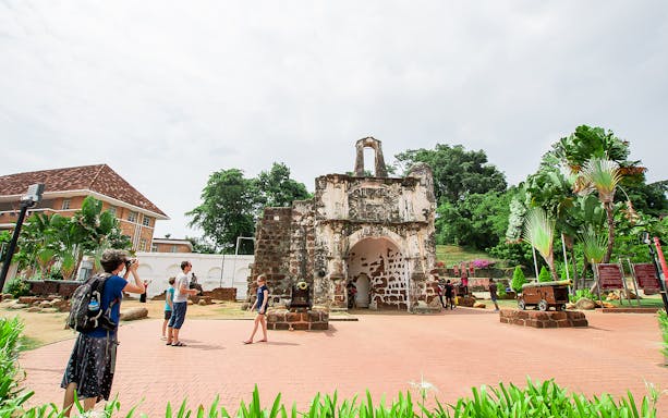 A Famosa fortress ruins in Malacca with tourists exploring the site.