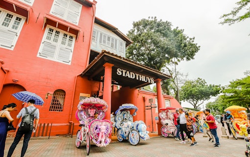 Stadthuys in Malacca with colorful trishaws, part of the Historical Malacca Sightseeing Tour from Kuala Lumpur.