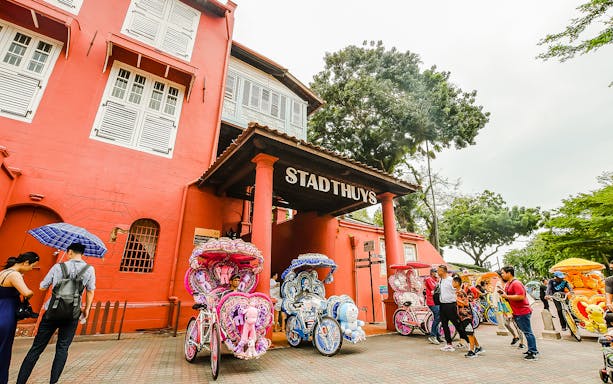 Stadthuys in Malacca with colorful trishaws, part of the Historical Malacca Sightseeing Tour from Kuala Lumpur.