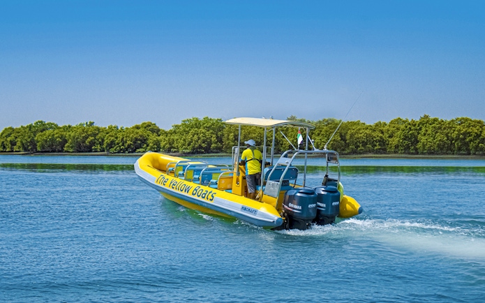 Speedboat on Yas Island tour with lush greenery in the background.