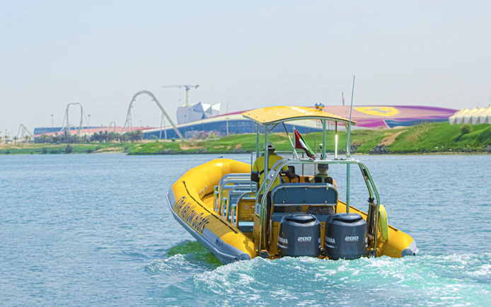 Speedboat on Yas Island tour with theme park in background.