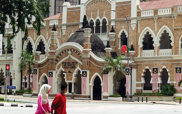 Sultan Abdul Samad Building in Kuala Lumpur with Malaysian flags.