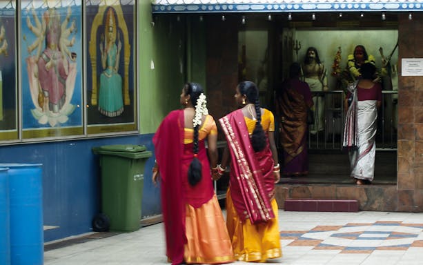 Women in traditional attire entering a Hindu temple in Kuala Lumpur during a private guided walking tour.