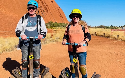 Visitors on Segways touring Uluru, Australia.