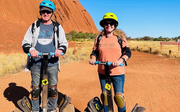 Visitors on Segways touring Uluru, Australia.