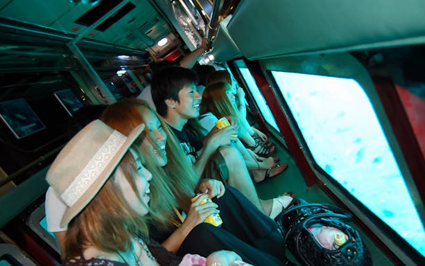 Passengers enjoying views on Okinawa underwater sightseeing boat ride.