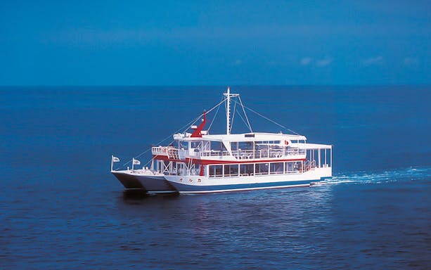 Okinawa sightseeing boat on clear blue ocean.