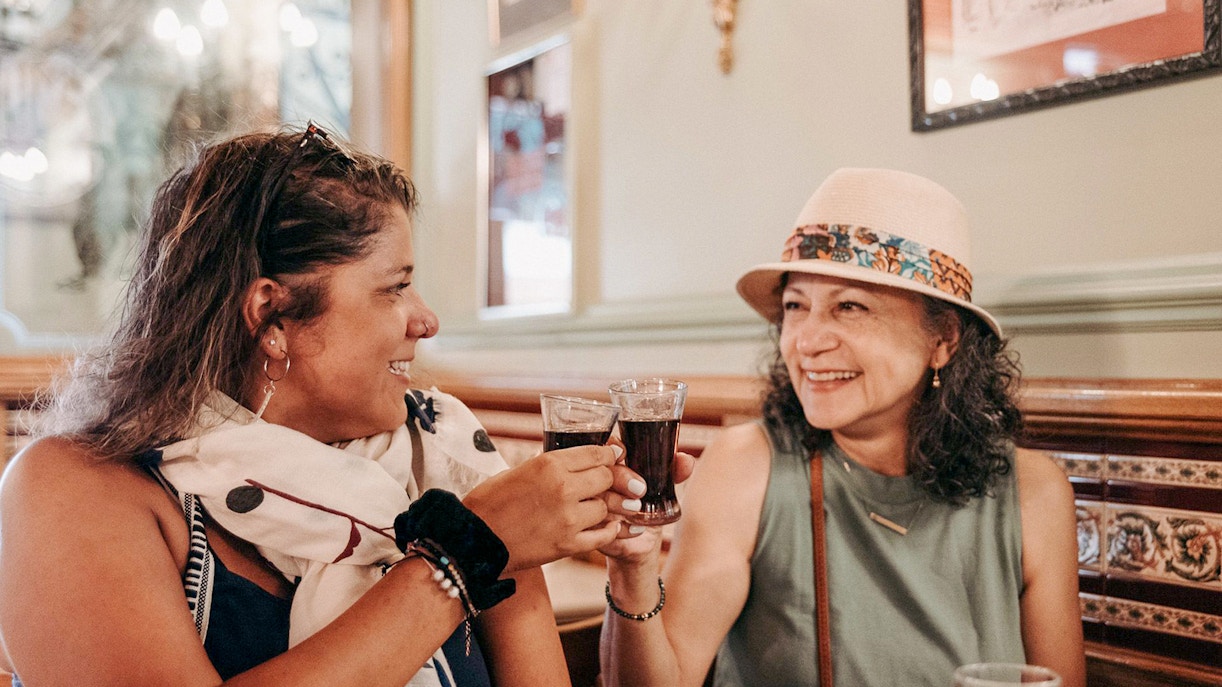 Grupo desfrutando de tapas em um bar tradicional, com ambiente acolhedor e descontraído.