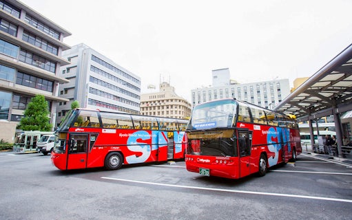 Kyoto sightseeing hop-on hop-off buses parked at a city bus terminal.