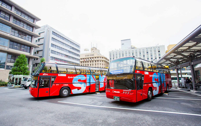 Kyoto sightseeing hop-on hop-off buses parked at a city bus terminal.