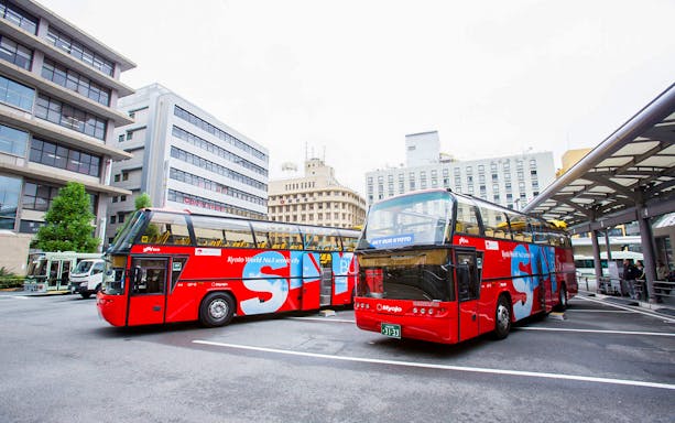 Kyoto sightseeing hop-on hop-off buses parked at a city bus terminal.