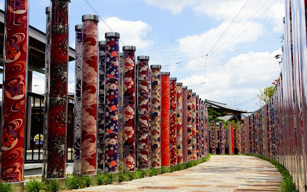 Colorful kimono fabric pillars at Randen Arashiyama Station, Kyoto, Japan.