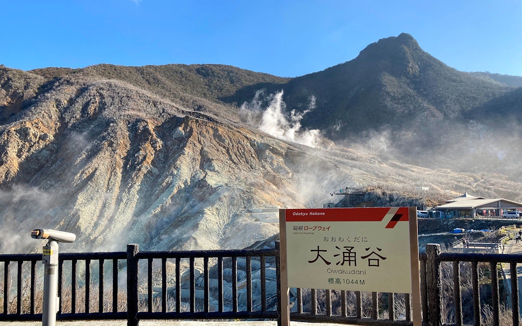Owakudani volcanic landscape with steam vents in Hakone, Japan, viewed from observation area.