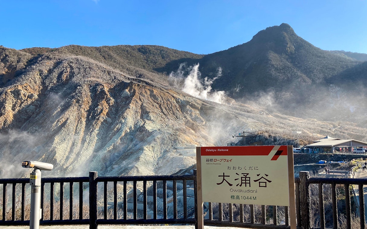 Owakudani volcanic landscape with steam vents in Hakone, Japan, viewed from observation area.