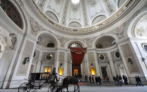 Horse-drawn carriage inside Hofburg Palace, Vienna, during Empress Sisi tour.