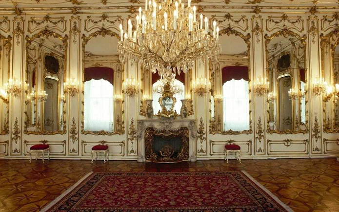 Elegant room in Empress Sisi’s Vienna with ornate mirrors and chandelier.