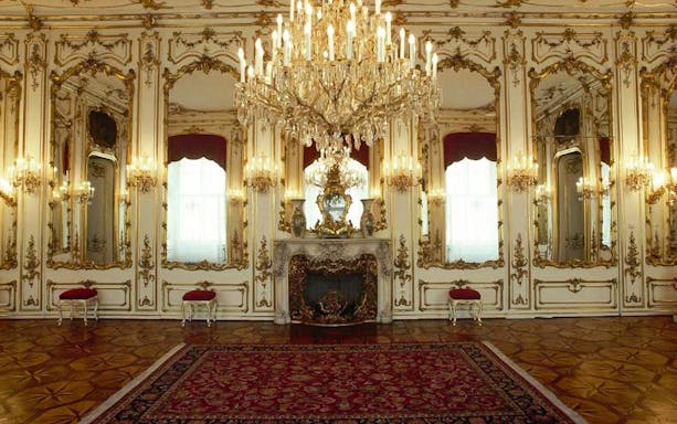 Elegant room in Empress Sisi’s Vienna with ornate mirrors and chandelier.