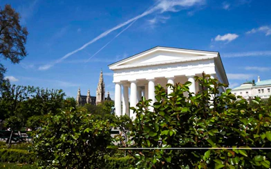 Vienna's Theseus Temple with St. Stephen's Cathedral in the background on a sunny day.