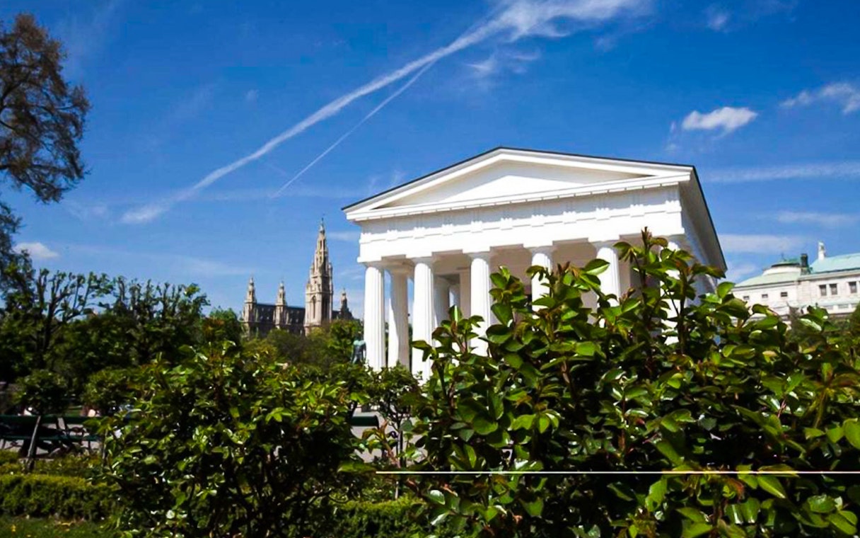 Vienna's Theseus Temple with St. Stephen's Cathedral in the background on a sunny day.
