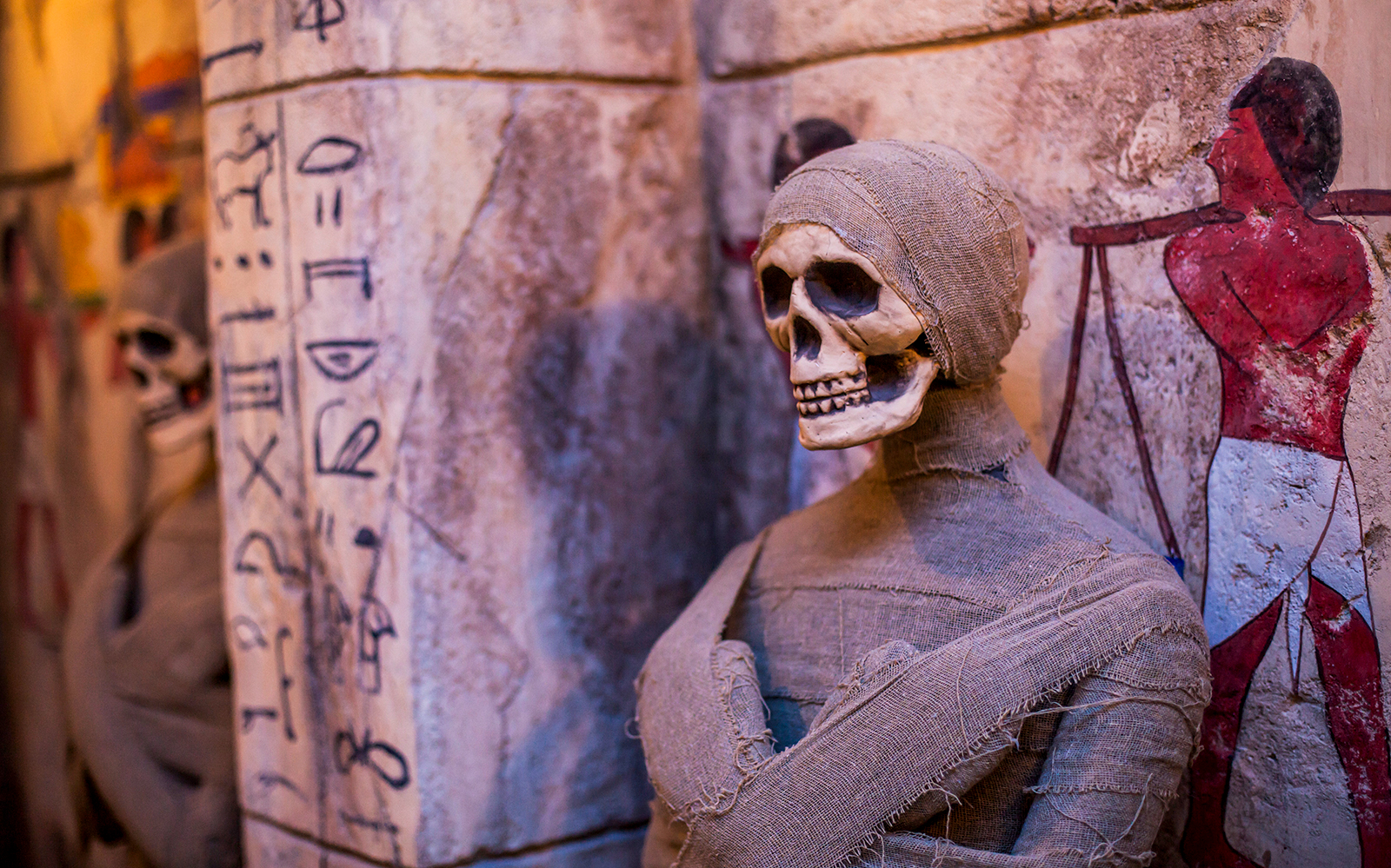 Mummified skeleton display at Ghost Museum Penang with ancient hieroglyphs.